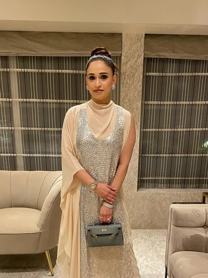 The full look with the high top knot, showcasing how it complements a contemporary outfit with a high neckline. It's a statement of confidence.