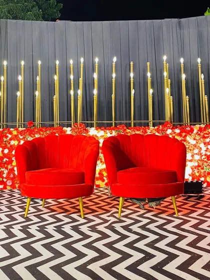 Simple yet striking decor featuring modern red velvet chairs against a backdrop of glowing vertical lights, creating a sophisticated photo spot.