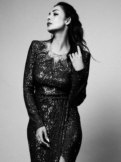 A classic black and white portrait of Malaika Arora. The simple background and studio lighting create a timeless and glamorous look.