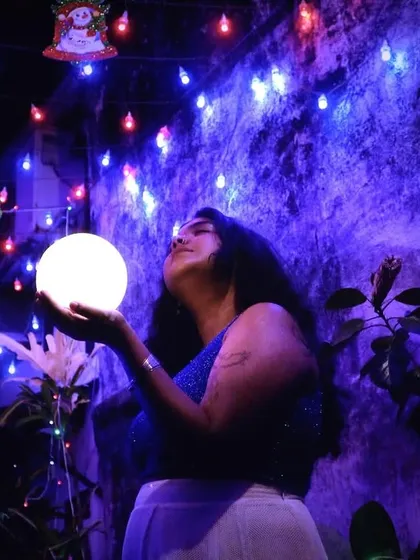 A magical still from the "Noor" visualizer shoot. Holding a ball of light against a backdrop of festive lights, this image perfectly captures the song's title and essence.