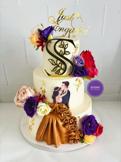 A personalized three-tier engagement cake featuring a custom photo, a beautiful fondant gown, and a monogram. This cake is a perfect example of how I can incorporate your personal story into the design.
