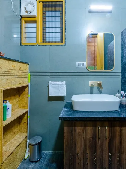 The vanity area is simple and functional, with a wooden cabinet providing storage below the sink.