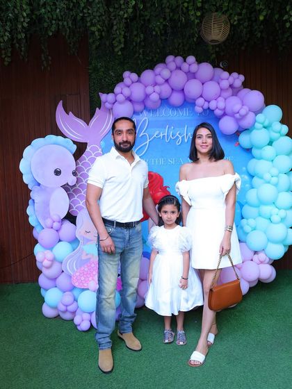 Another beautiful family photo in front of a different mermaid backdrop, showing the versatility of our decor options. This one features a circular balloon arch and a grassy floor for a unique look.