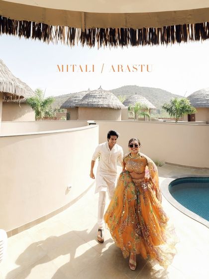 A stylish shot of a couple walking by the pool during their pre-wedding festivities. This captures a relaxed moment amidst the vibrant celebrations.