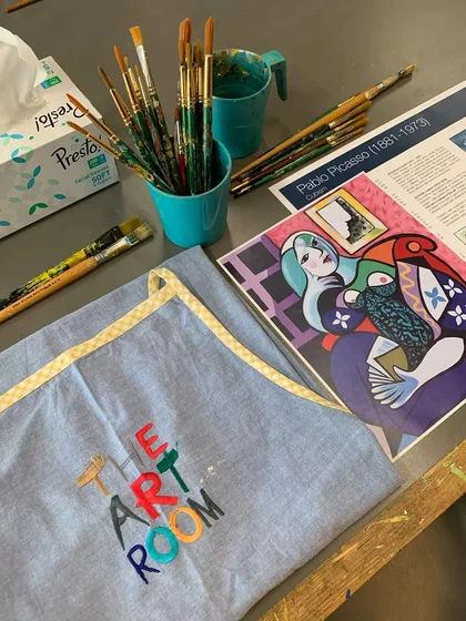 The essentials for a Picasso workshop: a branded apron, brushes, and a clear reference image to inspire our artists.