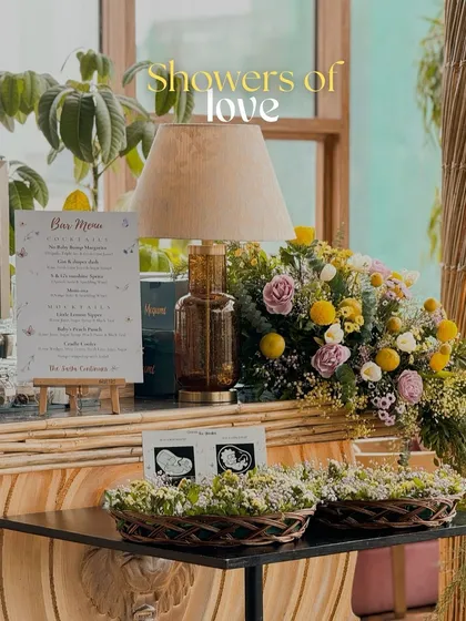 A cozy corner at a baby shower. The bar menu is displayed next to a vintage-style lamp, with baskets of baby's breath and a sonogram picture adding a deeply personal and sweet touch.