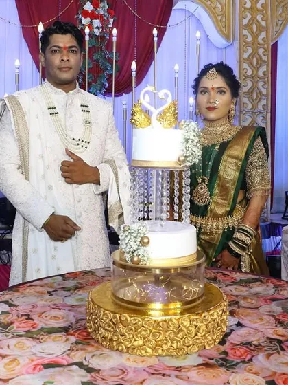 The couple poses with their stunning three-tier engagement cake, featuring a swan topper and crystal separators, before the cake cutting ceremony begins.