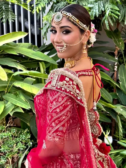 A smiling model looking over her shoulder, giving a glimpse of her beautiful floral bun. This hairstyle is a perfect blend of tradition and natural beauty.