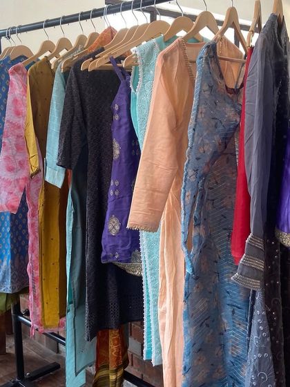 A behind-the-scenes look at a clothing rack with sourced outfits for the characters. This is where the magic begins, with a curated collection of colors, fabrics, and styles ready for fitting.