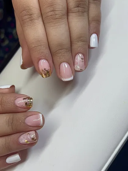 A mixed-style set featuring a classic French tip alongside white and gold foil nails.