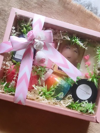 This bridesmaid gift hamper is designed to pamper. It includes a custom name soap, body wash, body lotion, bath salts, and other treats, all elegantly arranged in a pink gift box.