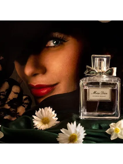 A product shoot for Dior perfume, where the model's mysterious look complements the product's branding. This image combines portrait and still life techniques to create a complete advertising visual.