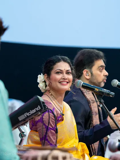 A candid shot of Priyanka Barve on stage, with white flowers in her hair completing the traditional look.