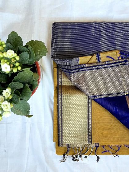 This Maheshwari saree has a unique color combination of grey and mustard yellow with a royal blue border.