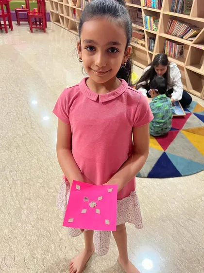A smiling student with her completed craft project from the spring camp. We love seeing the pride they take in their creations.