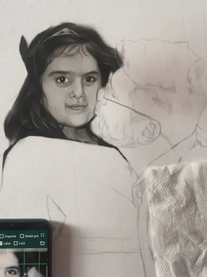 Here you can see my reference photo on the phone next to the ongoing sketch. This helps me ensure every detail is captured accurately.