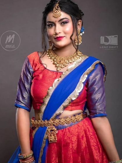 A model in a vibrant half saree, accessorized with a simple and elegant gold-plated choker and hip belt.