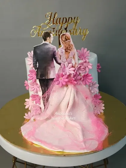 An anniversary cake with a lovely illustration of a couple and a flowing dress made of delicate wafer paper.