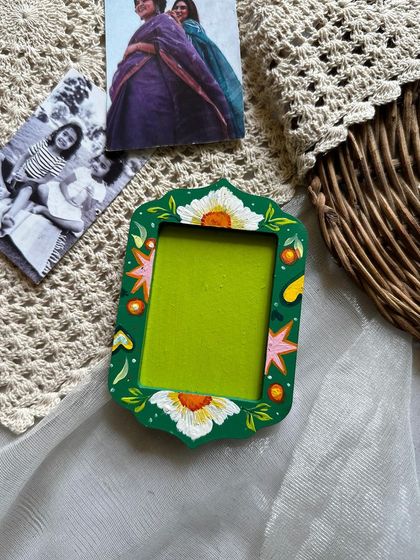 This green photo frame magnet features a beautiful white floral pattern.