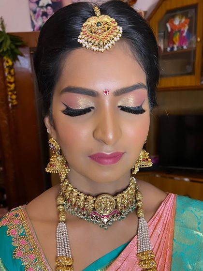 A frontal view of the temple wedding makeup, showing the symmetry of the winged eyeliner and the beautiful contouring that enhances her features.