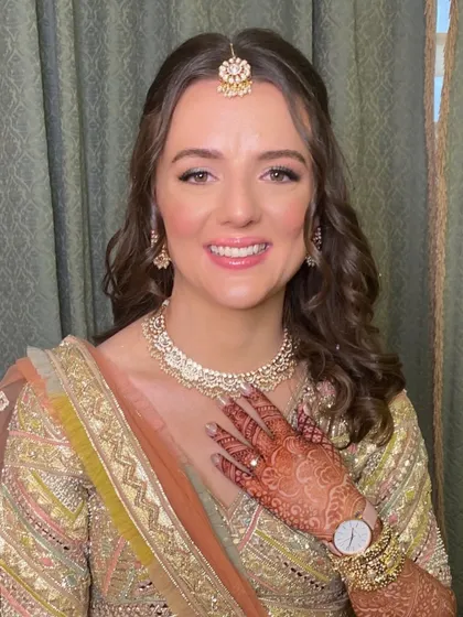 A happy bride ready for her Mehendi. The makeup is fresh and radiant, perfect for a day of celebration.
