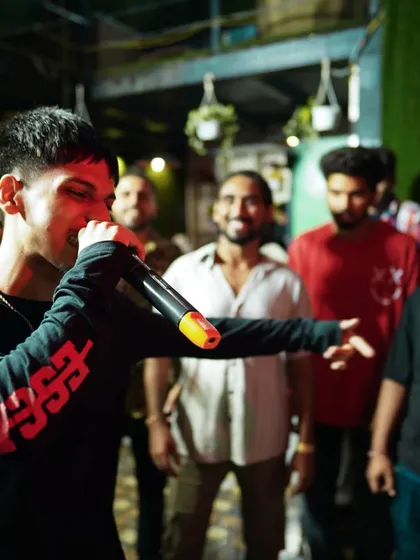 A rapper connecting with the audience during a freestyle session. The cypher is a core part of our workshops, celebrating the culture of hip-hop and lyrical skill.