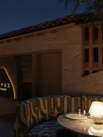 A cozy banquette on the Zuvaah terrace, with patterned upholstery and a small table lamp. The design creates intimate nooks for guests to enjoy the open-air setting.