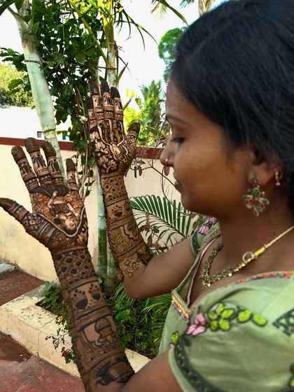 The bride admiring her intricate mehendi. This design tells a story with portraits and symbols that are meaningful to the couple.