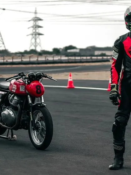 A rider standing next to their GT 650 on the track.