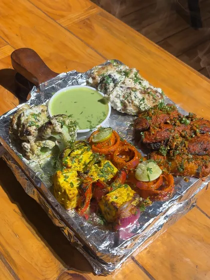 Get a taste of our kitchen's best with this sizzling tandoori platter. It’s packed with a variety of paneer tikka, malai broccoli, and soya chaap, all grilled to perfection in our tandoor.