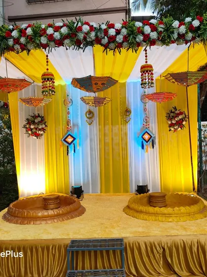 For a Haldi ceremony, it's all about bright, happy colors. This setup features a traditional yellow drape backdrop, decorative Rajasthani umbrellas, and low seating (baithak) for the rituals, making it perfect for photos and creating a festive vibe.