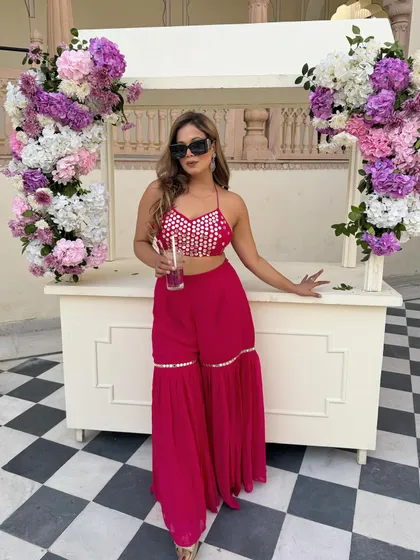 A pretty pink affair for a daytime Mehendi. This sharara set with mirror work is festive, fun, and perfect for a celebration.