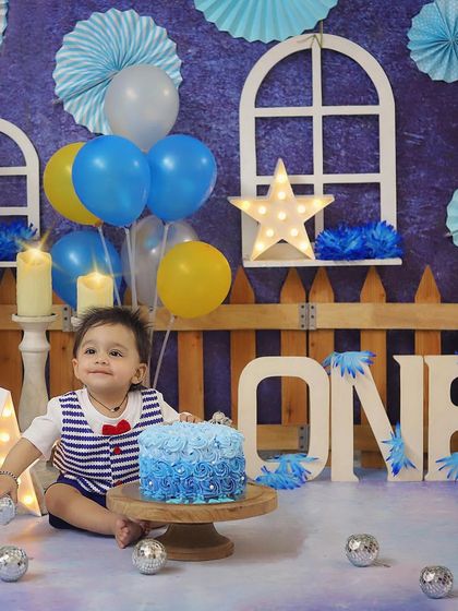 This little sailor is all set for his blue-themed cake smash! The nautical-inspired outfit and beautiful blue ombre cake make this first birthday session so special.