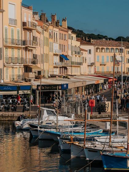 The colorful harbor front of St. Tropez, with boats docked along the quay. The warm tones of the buildings are characteristic of the South of France.
