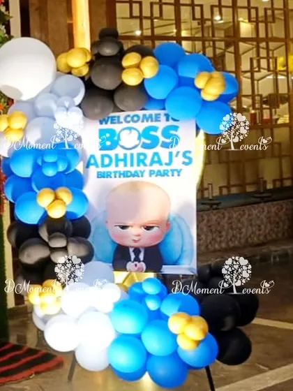 A personalized welcome sign for the Boss Baby party, framed with a stylish arrangement of blue, black, and white balloons.
