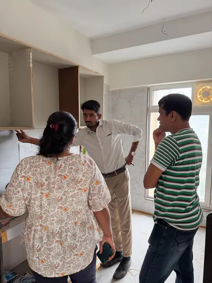 Explaining the layout of the kitchen cabinets to the clients as the woodwork progresses.