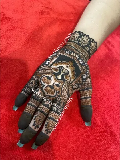 A bold and striking peacock design on the back of the hand. The use of negative space makes the peacock figure stand out beautifully.