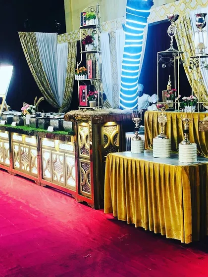 Another perspective of the engagement dinner setup, highlighting the grand scale and cohesive gold and white theme. We use decorative elements and tiered displays to add height and visual interest.