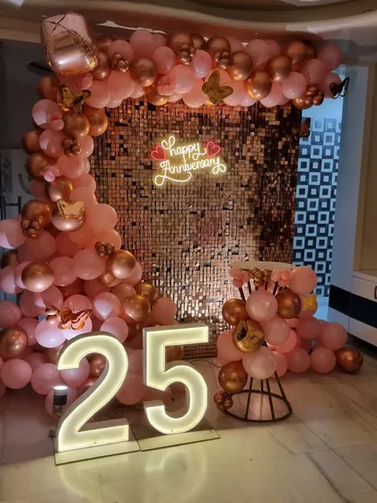 This image shows the full scale of the sequin wall and balloon arch, creating an impressive photo booth for the anniversary celebration.