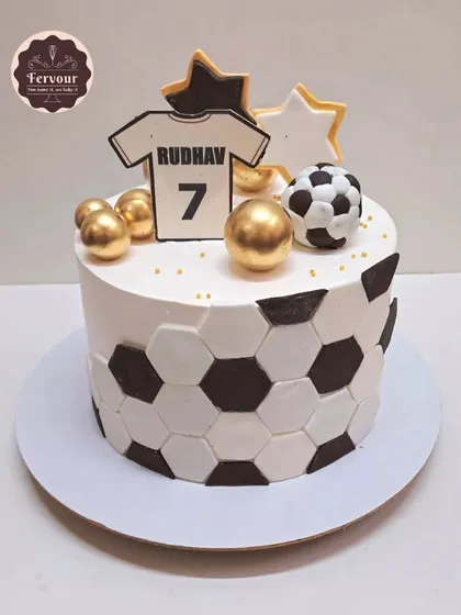 A stylish football theme cake with a black and white hexagonal pattern. This 2 kg chocolate mousse cake is topped with a jersey and golden stars for a winning design.