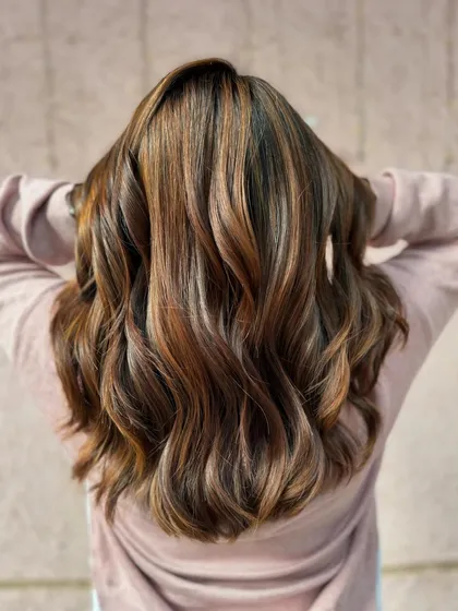 A beautiful brunette balayage for a beautiful bride. The soft waves highlight the seamless blend of colors, creating a timeless and elegant look for her big day.
