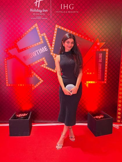 Posing on the red carpet at a corporate show. I am always professional and ready for any event.