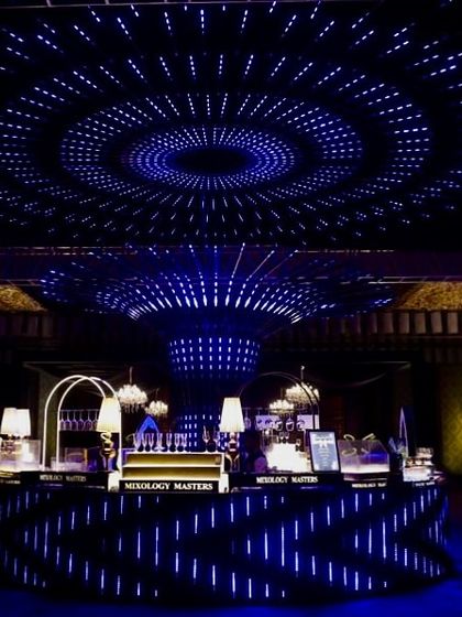 A wide shot of the techno-themed Sangeet, showing the incredible scale of the circular LED ceiling installation over the main bar area.