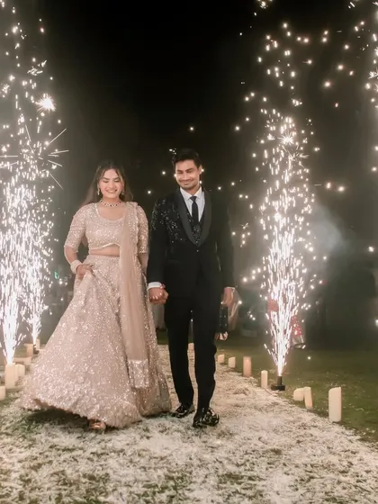 A grand, celebratory entrance for Amit and Pallavi, walking through an aisle of fireworks, creating a spectacular and memorable photograph.
