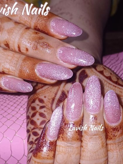 A soft and shimmery pink glitter nail set, perfect for complementing intricate bridal mehendi designs.