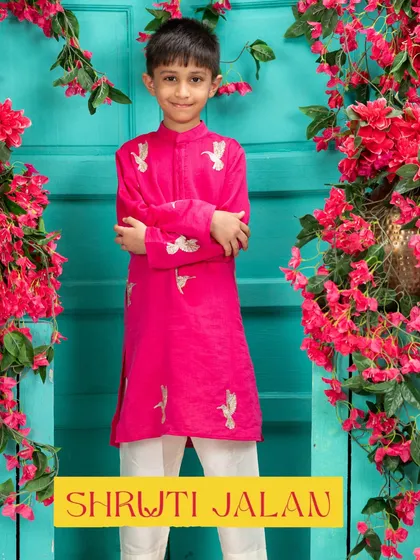 This little boy is ready for Rakhi in a festive fuchsia pink kurta with delicate bird embroidery. It's a vibrant and joyful look.
