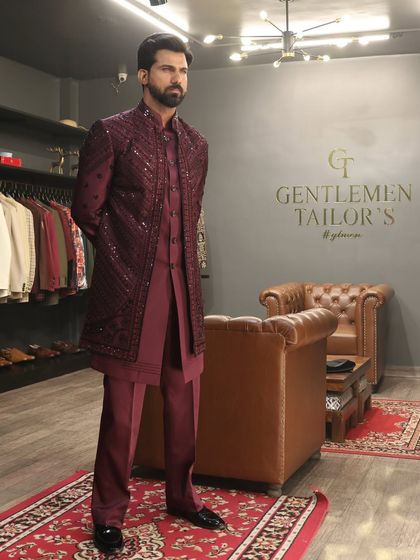 A formal pose showcasing the complete wine-colored Indo-western outfit. The coordinated kurta, trousers, and jacket create a cohesive and luxurious look suitable for any grand celebration.