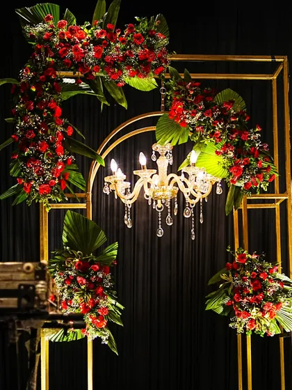 A detailed shot of the golden framework and red floral decor, showcasing the elegant combination of metal and nature that defined this celebration's aesthetic.