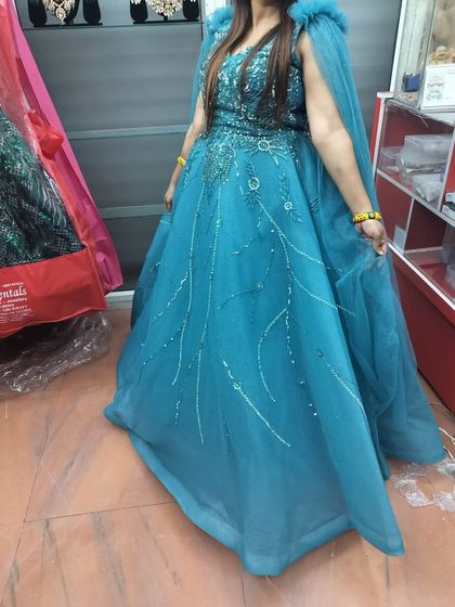 A client trying on the turquoise blue gown at my store. You can see how the color brightens up the look instantly.