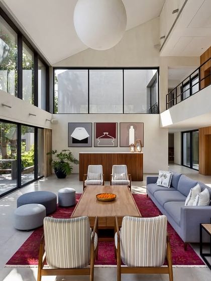 A wider perspective of the Mango Orchard House living room, showing the mezzanine level and the double-height volume. This open-concept design enhances the sense of space and allows light to travel freely throughout the home.